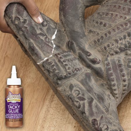 Picture of 15600 Aleenes Original Tacky Glue 2 fl. oz. next to statue being repaired
